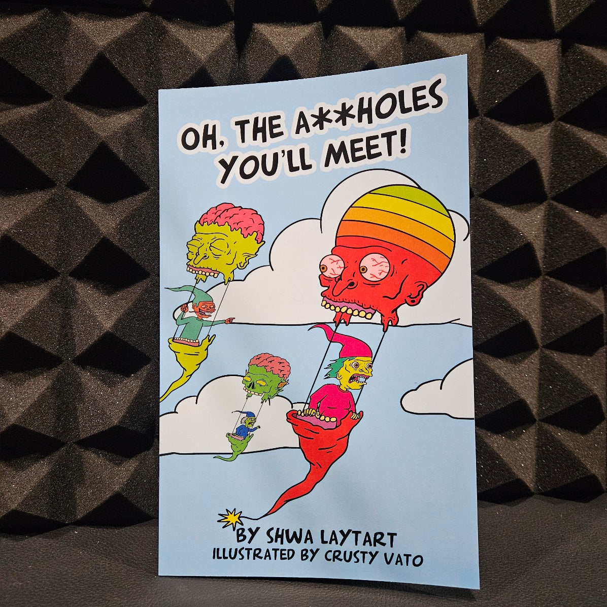 book cover with colorful characters and text with clouds in front of a black textured background